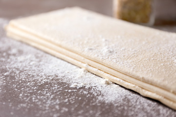 Canvas Print - Flaky dough sheets on table, closeup