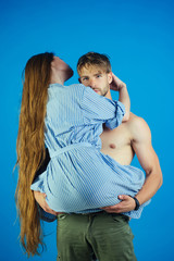 Wall Mural - Man hold woman in arms on blue background