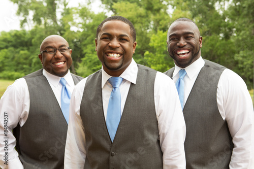 Valokuva  Groom and groomsmen smiling at a wedding.