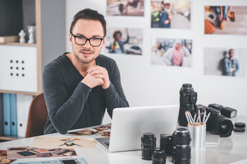 Aufkleber - Portrait of pensive bearded photographer working with pictures and laptop while sitting at table. Job concept