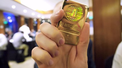 Poster - Close up of Male hand and gold bullion with Bitcoin symbol on it. Concept of Cryptocurrency physical bitcoin with gold bar and sunburst effect. BTC gold.