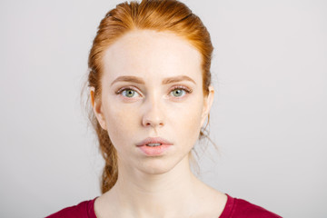 face of beautiful young redhead girl with clean fresh face and neutral emotions close up