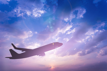 Wall Mural - silhouette of airplane take off on the colorful dramatic sky with cloud at sunset background