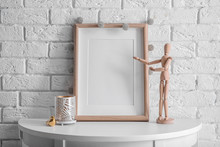 Mockup Of Blank Frame With Mannequin On Table
