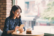 © makistock - Beautiful cute asian young businesswoman in the cafe, using mobile phone and drinking coffee smiling