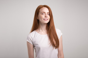 Wall Mural - Headshot Portrait of happy ginger girl with freckles smiling looking at camera. White background.