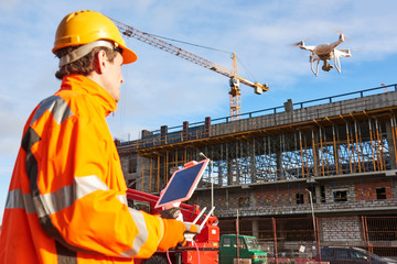 Wall Mural - drone operated by construction worker on building site