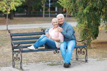 Poster - Mature couple sitting on bench outdoors