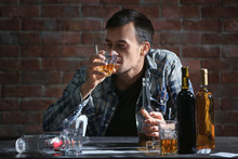 Man Drinking Whiskey And Smoking Cigarette While Sitting At Table. Alcoholism Concept