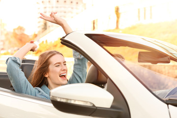 Beautiful young woman in car on road trip