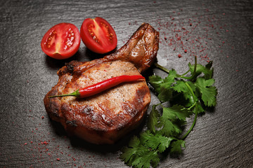 Wall Mural - Tasty grilled rib with vegetables on dark background