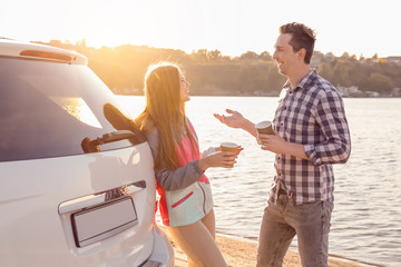 Sticker - Young couple with coffee standing near car on river bank