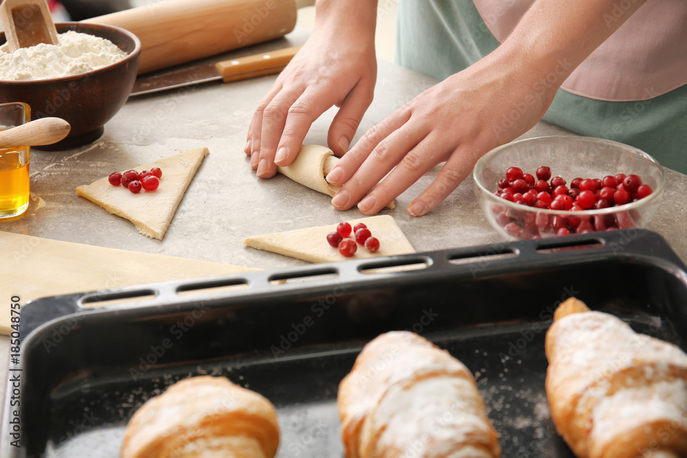 Woman preparing puff pastry at table