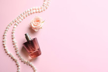 Composition With Bottle Of Perfume, Flower And Pearls On Color Background
