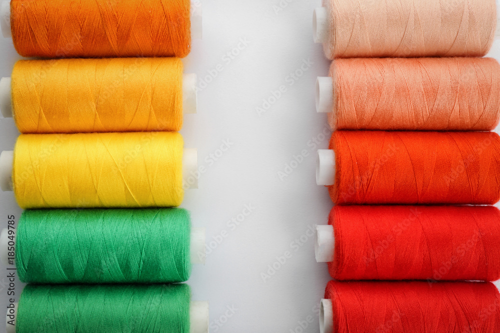 Colorful sewing threads on white background