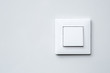 a light switch on gray wall.