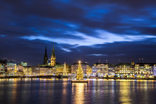 Christmas In Hamburg. Panoramic View Of The Decorated City Center From Alster Lake, View To Hamburg Rathaus And A Christmas Tree Installed In The Center Of The Lake. Atmosphere Before The New Year. 
