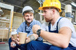 © Seventyfour - Portrait of two builders wearing hardhats taking break from work drinking coffee and resting on site