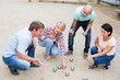 © JackF - Cheerful males and females playing petanque
