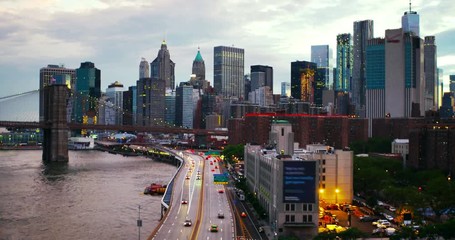 Poster - New York, USA. Aerial view on the city skyline in New York City, USA at night. Famous skyscrapers of the concrete jungle and car traffic. Brooklyn bridge