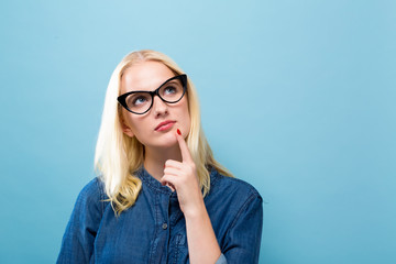 Wall Mural - Young woman in a thoughtful pose on a solid background