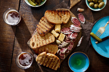 Sticker - Italian snacks Bruschetta on wooden table with dark beer