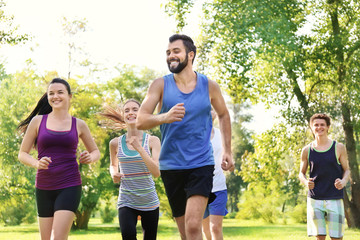 Wall Mural - Group of young people running in park