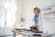 © LUMINA IMAGES - Elegant businesswoman interior designer working standing at her office an looking at wood palette.