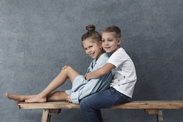 A portrait of little girl and a boy on the gray background