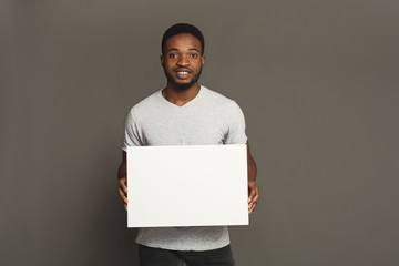 Wall Mural - Picture of young african-american man holding white blank board