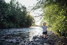 Playful Boy Throwing Pebbles In River
