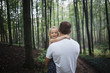 © Cavan Images - Father carrying his daughter while standing in forest