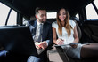 © ASDF - man and woman discussing work documents in taxi