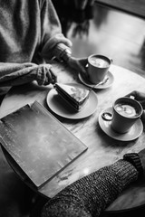 Female and man hands with cups of coffee on the background of a wooden table