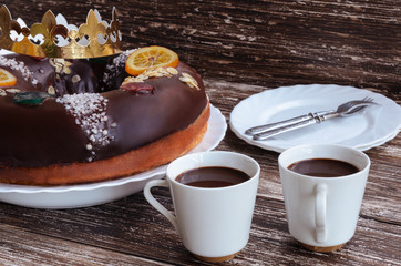 Wall Mural - Roscon de reyes, chocolate spanish desert to celebrate Epiphany or Dia de Reyes Magos , Three Wise Men Day. Spanish Christmas cake with cups of hot chocolate on wooden background.