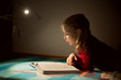 © spass - Pretty little girl reading book in her hiding place with flashlight at darkness
