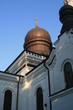 ciemna kopuła białego budynku cerkwii prawosławnej na tle błękitnego nieba w słoneczny dzień