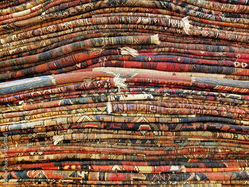 Fotografie, Obraz Stack of colorful handmade antique Oriental style rugs and carpets background te