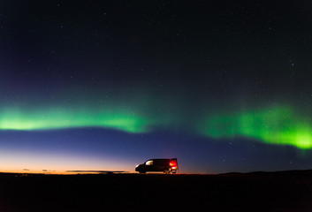 The northern lights above a camper van after sunset in Iceland. 