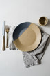 © Daring Wanderer/Stocksy - Handmade two toned neutral and light blue modern ceramic pottery plate on white table