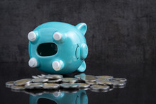 Saving Money Problem With Empty Piggy Bank Lay On Dark Black Table With Coins Using As Broke Or Personal Financial Crisis