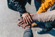 © MyMicrostock/Stocksy - Group of friends stacking hands