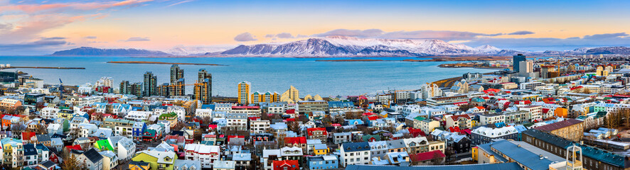 aerial panorama of downtown reykjavik at sunset with colorful houses and snowy mountains in the back