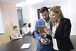 © NDABCREATIVITY - Attractive business couple using tablet in their company