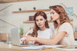 © LIGHTFIELD STUDIOS - beautiful young businesswomen working with laptop together at office