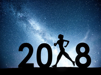 Silhouette of a young girl doing fitness. 2018 new year background of the Milky Way galaxy on a bright star dark sky tone