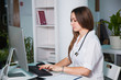 © okfoto - Female doctor consulting patient by internet. Advises by web camera at clinic. Health medicine diagnostics concept