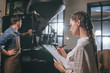 © LIGHTFIELD STUDIOS - selective focus of woman checking colleagues work during coffee roasting process