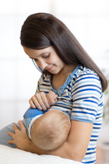 Wall Mural - Young woman breast feeding baby.