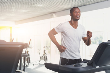 Young man in gym run on treadmill